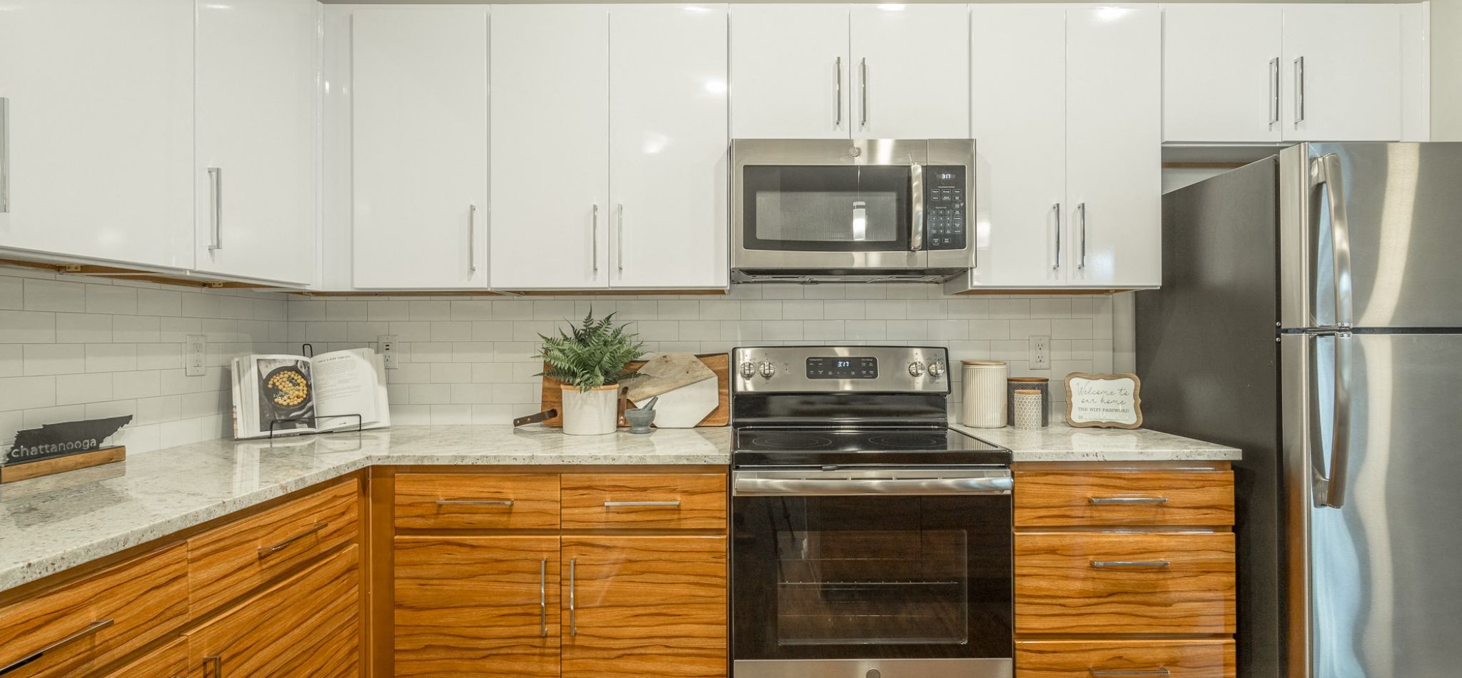 Hawthorne at the W apartment kitchen with granite countertops, stainless steel appliances, and ample cabinet storage