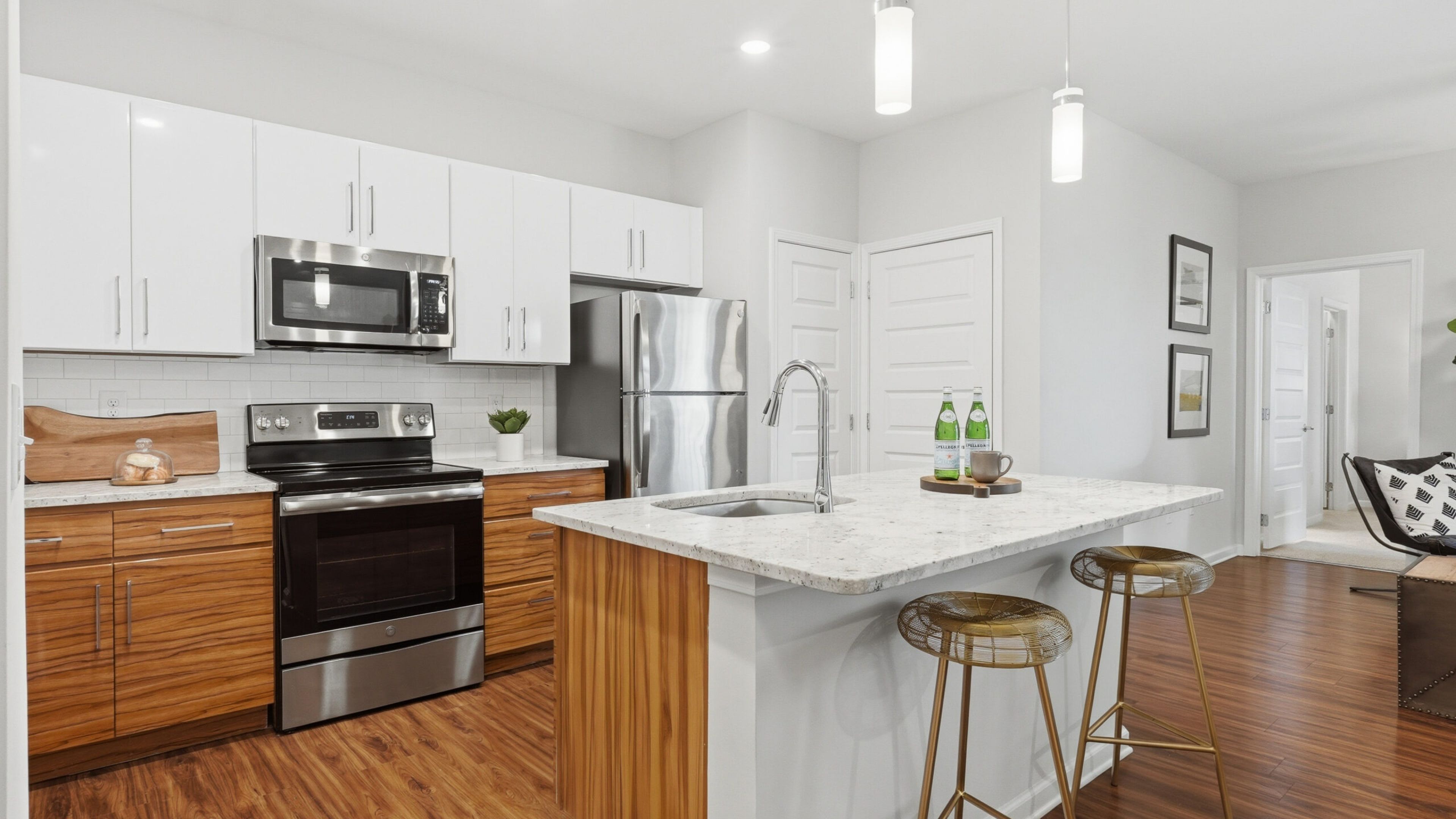 Hawthorne at the W apartment kitchen and living area with granite countertops, stainless steel appliances, and ample cabinet storage