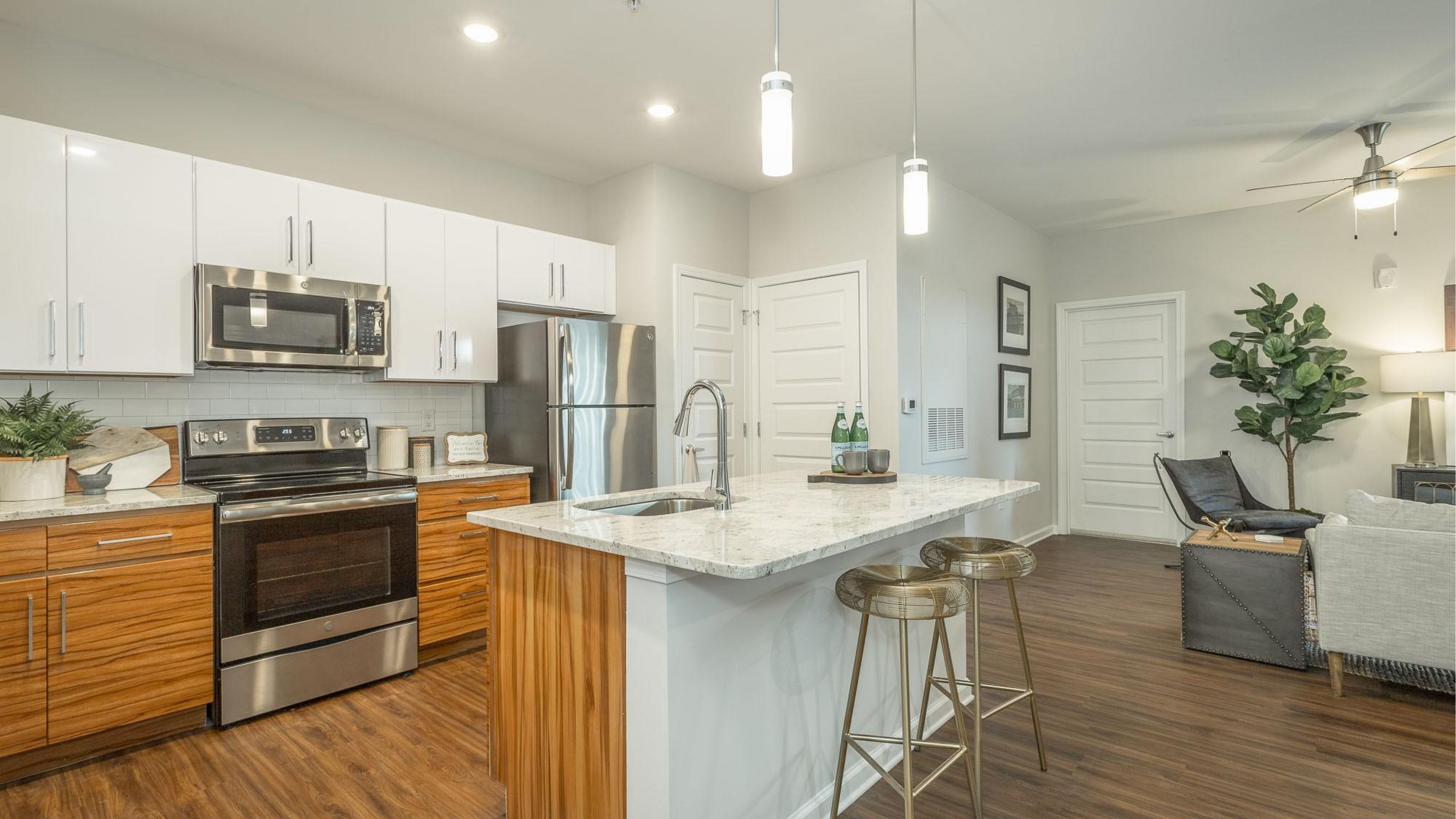 Hawthorne at the W apartment kitchen and living area with granite countertops, stainless steel appliances, and ample cabinet storage